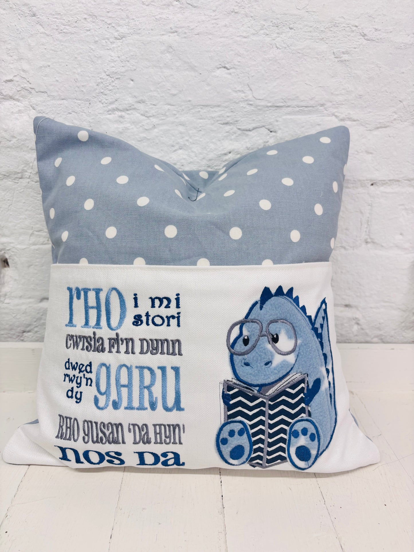 Blue Dino children’s Book Cushion available in Welsh or English.