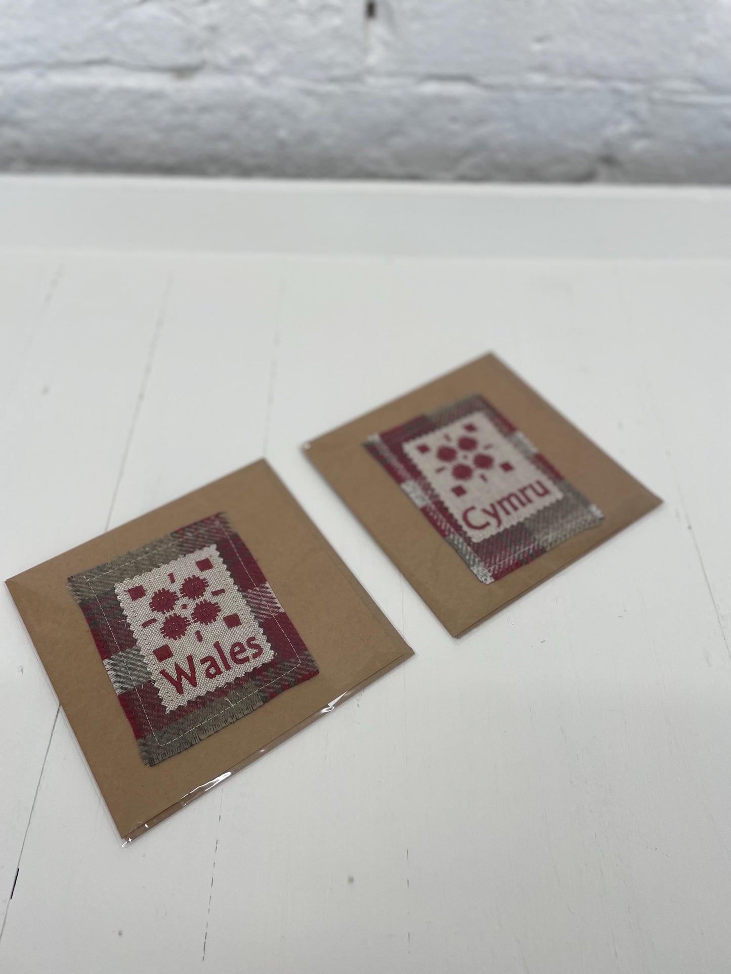 Handmade Card with machine embroidered Welsh blanket design & Cymru on Red Wool fabric square mounted on a Kraft card with envelope