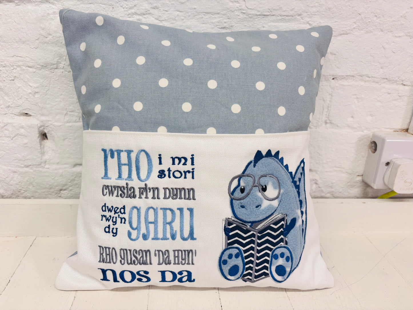 Blue Dino children’s Book Cushion available in Welsh or English.