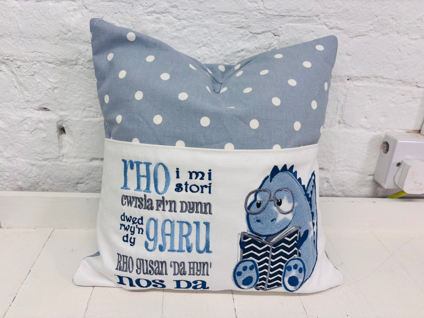Blue Dino children’s Book Cushion available in Welsh or English.
