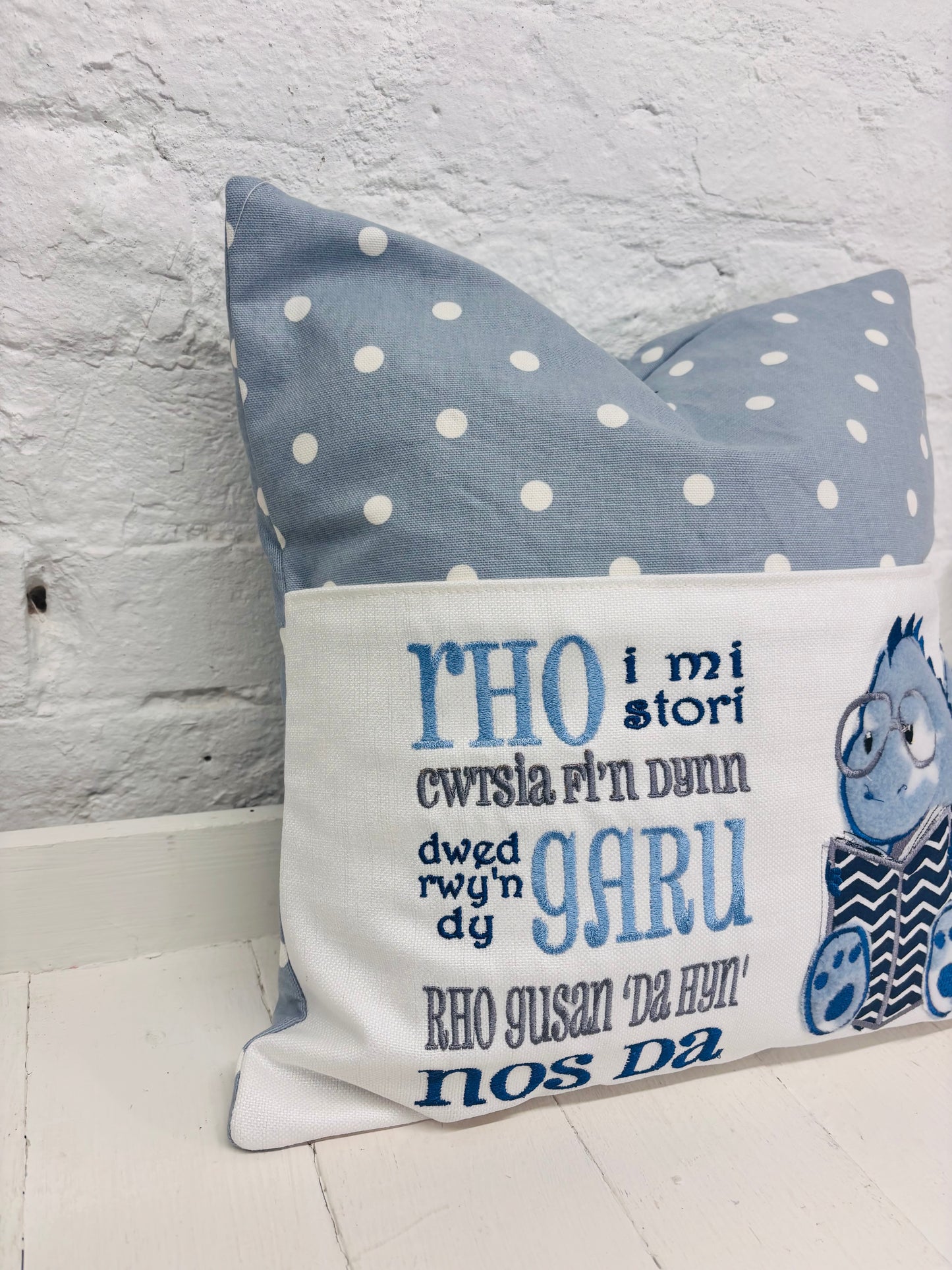 Blue Dino children’s Book Cushion available in Welsh or English.