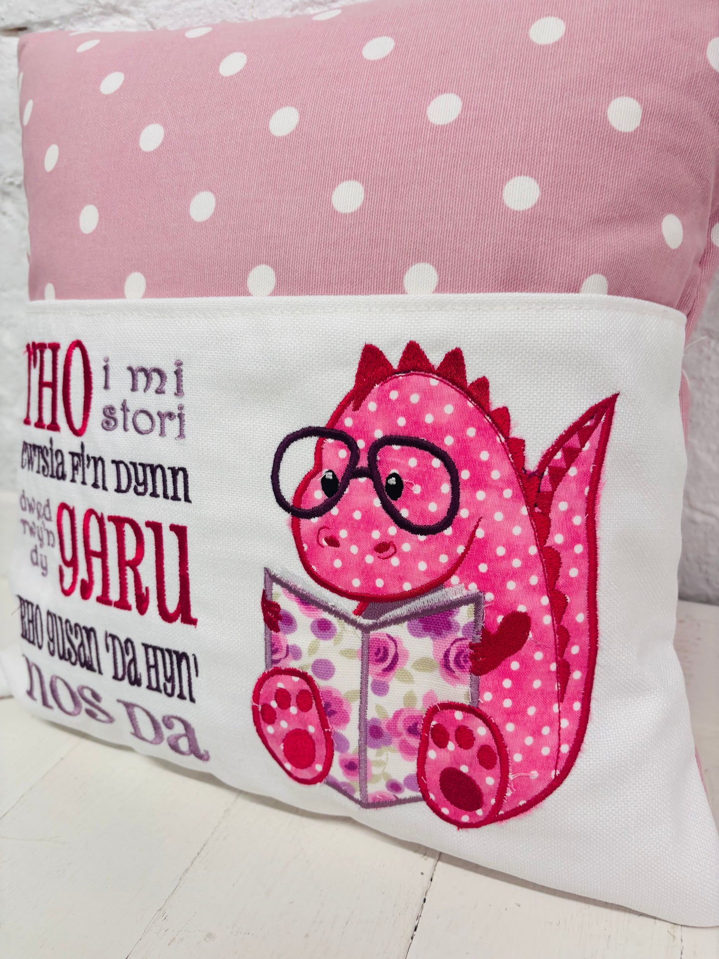 Pink Dino Children's Reading Book Cushion. available in Welsh and English