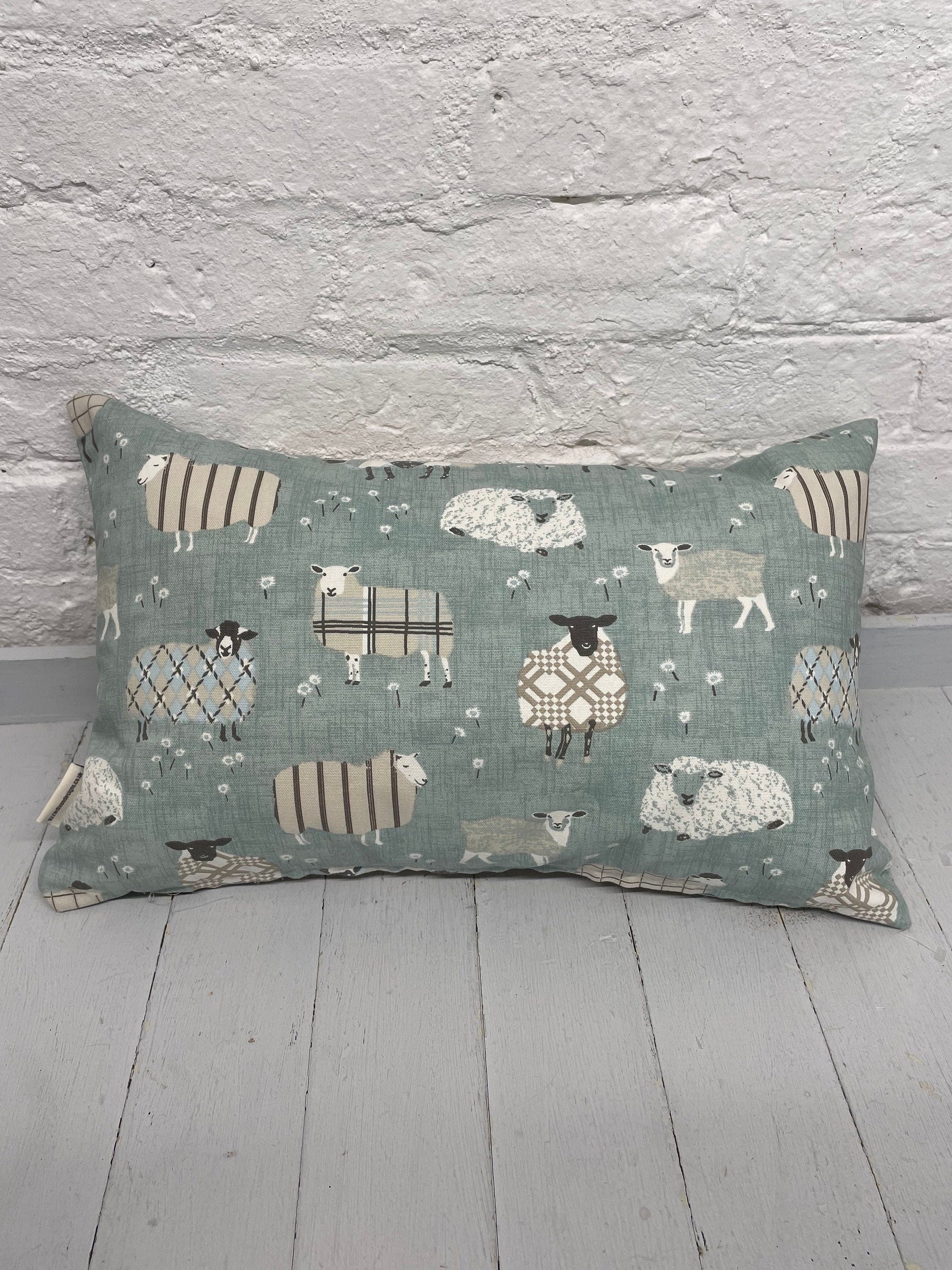 Cosy sheep in jumpers rectangle cushion with the word Cosy embroidered in duckegg on a coordinating taupe panel. Duck egg sheep in jumpers