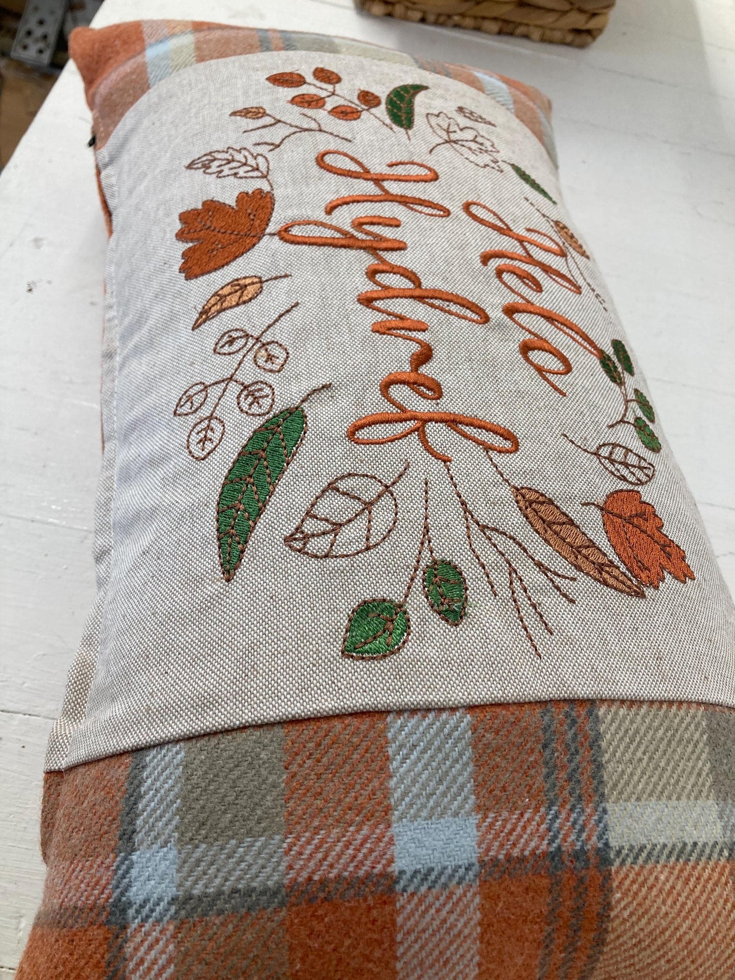Orange Tartan Cushion with embroidered Helo Hydref (Hello Autumn in Welsh) panel adorned with embroidered leaves.