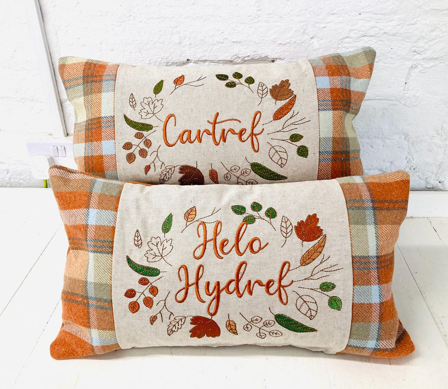 Orange Tartan Cushion with Cartref(Welsh for Home) panel adorned with embroidered leaves.