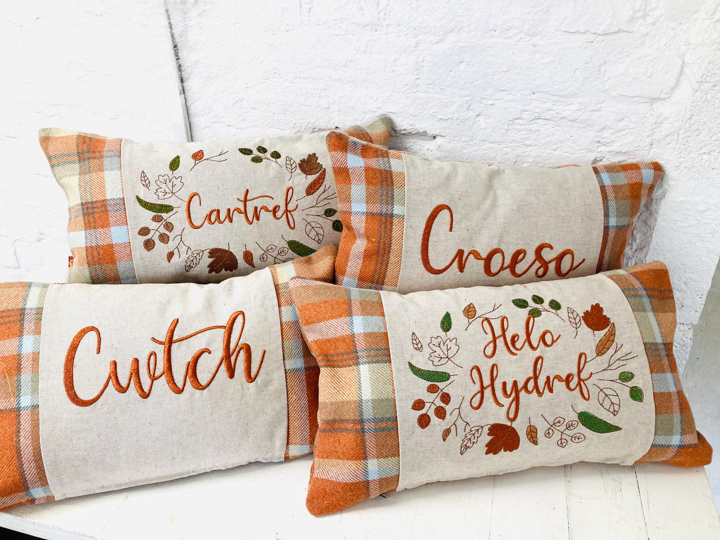 Orange Tartan Cushion with Cartref(Welsh for Home) panel adorned with embroidered leaves.