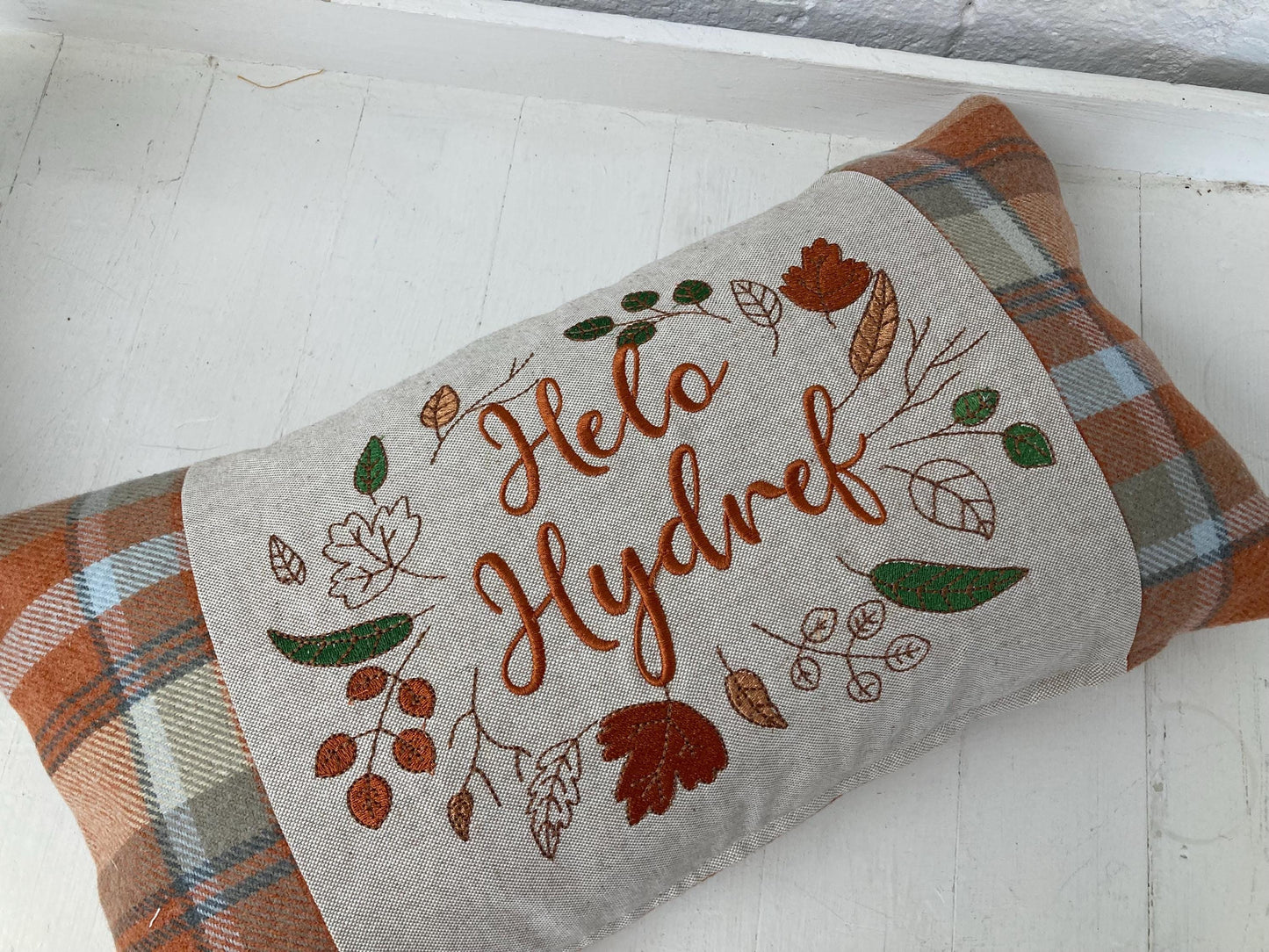 Orange Tartan Cushion with embroidered Helo Hydref (Hello Autumn in Welsh) panel adorned with embroidered leaves.