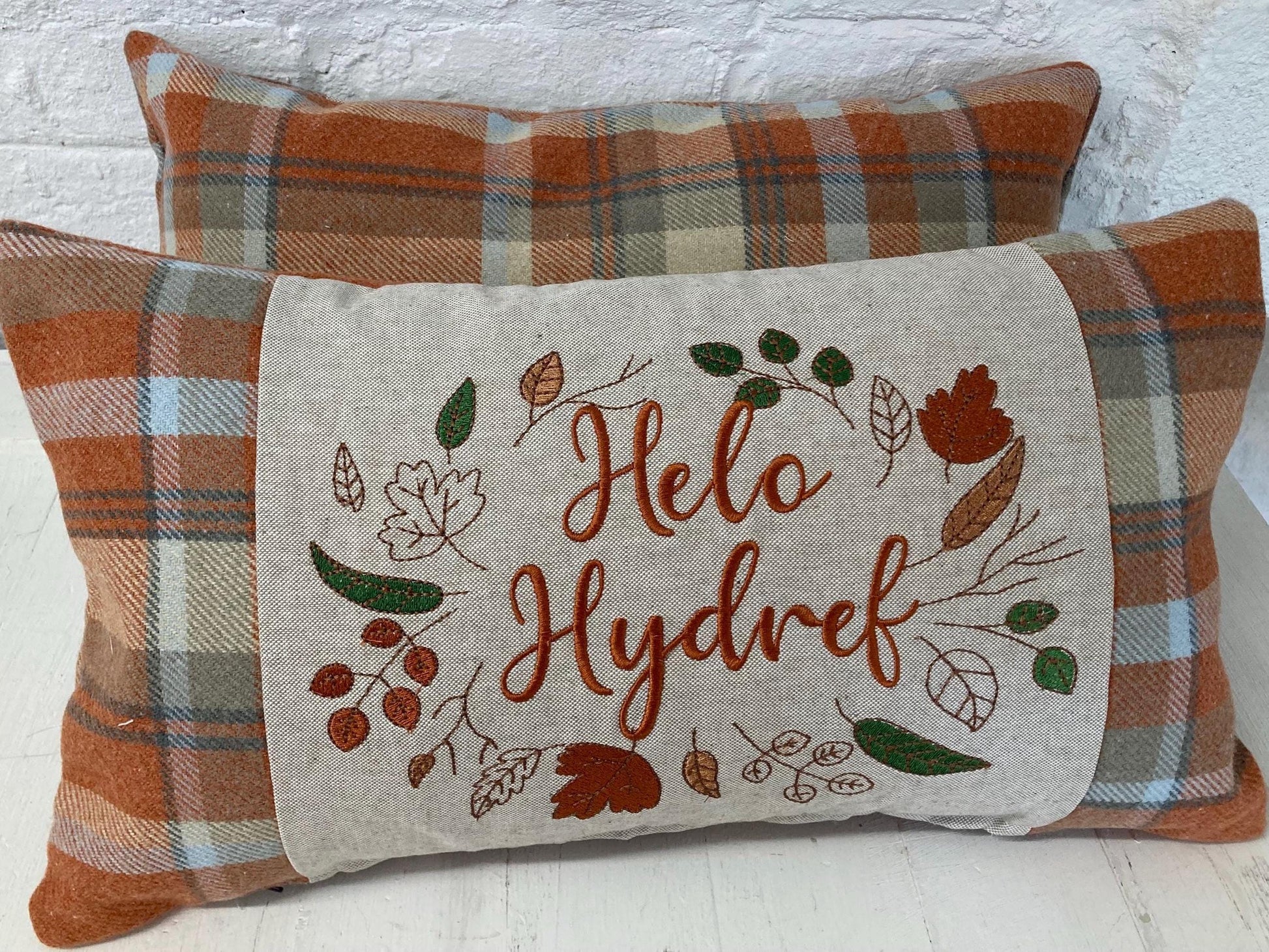 Orange Tartan Cushion with embroidered Helo Hydref (Hello Autumn in Welsh) panel adorned with embroidered leaves.