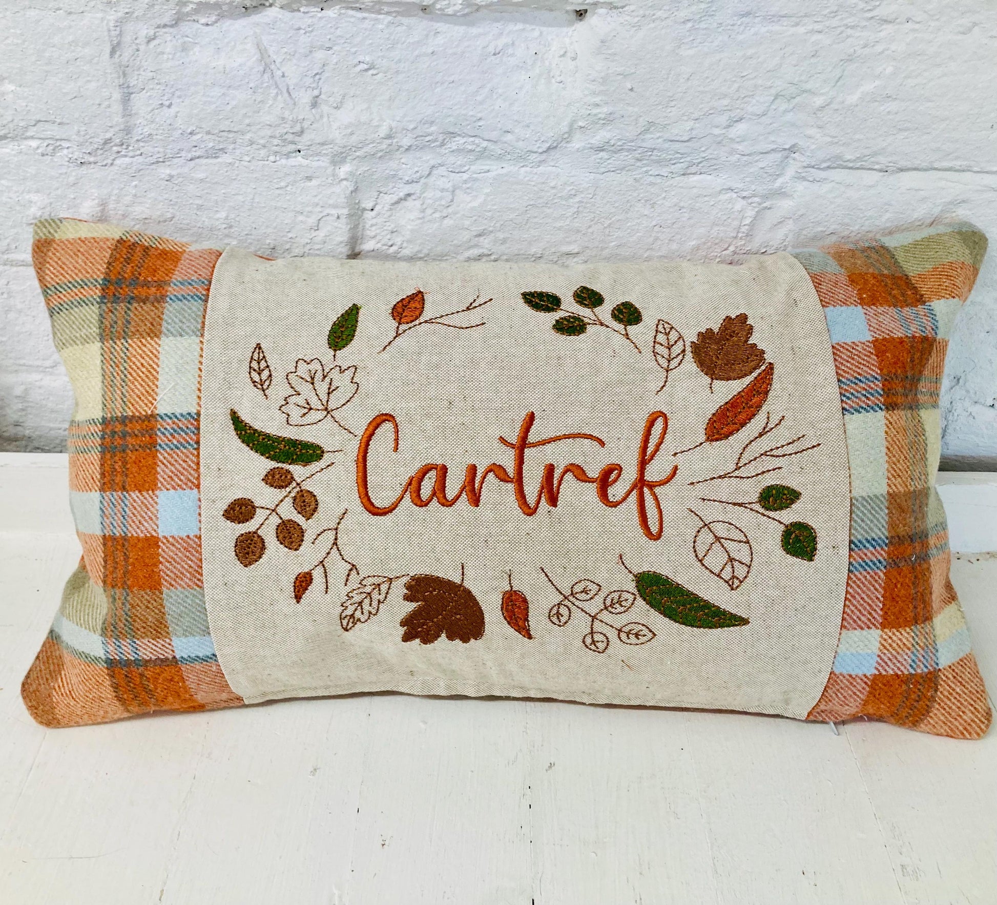 Orange Tartan Cushion with Cartref(Welsh for Home) panel adorned with embroidered leaves.